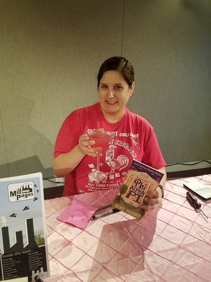 Sara at the Pride, Prejudice, and Pledging launch party with a martini and her book.